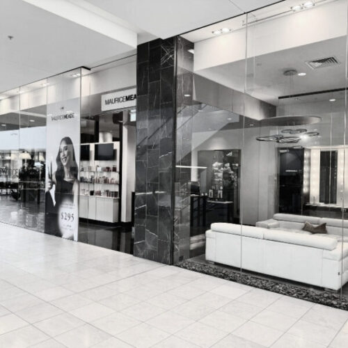 Maurice Meade store front with sleek glass walls and a promotional display.